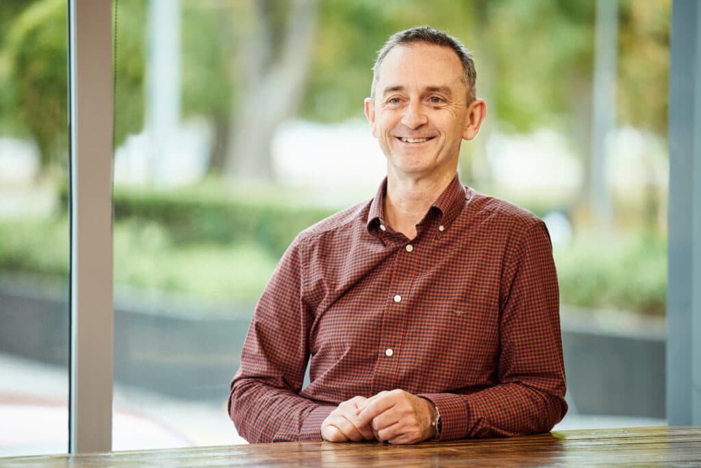 a picture of the Seequent CEO Graham Grant, leaning on a table