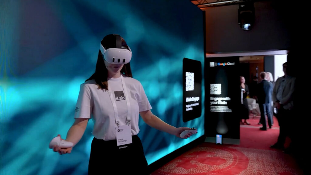 A screenshot from a promotional video for Bentley's YII awards, showing a woman in a white branded top giving a demonstration of VR technology.