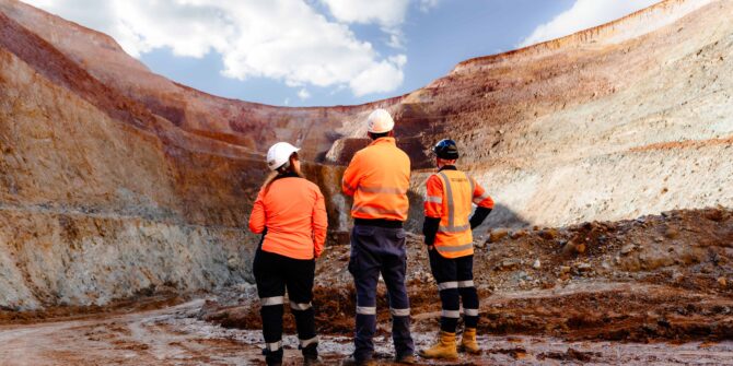 Mine staff inspect the side of an open pit mine