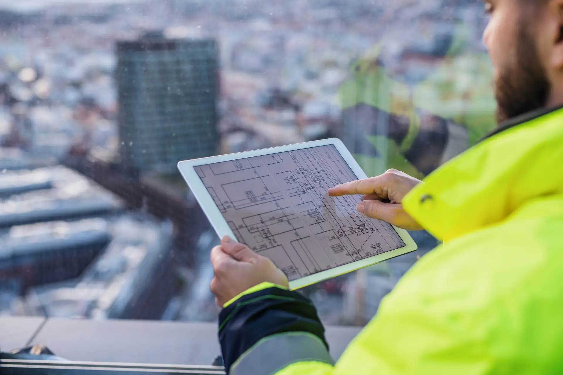 Midsection of man engineer with tablet on construction site, looking at blueprints. shutterstock_1669122547