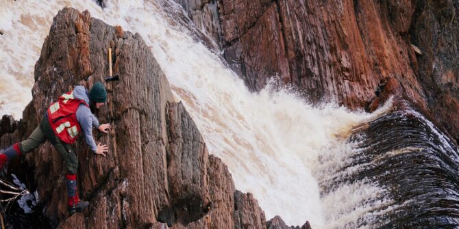 Deciphering an outcrop next to a sideways waterfall. Hands-on field mapping forces you to look at the situation from multiple angles.