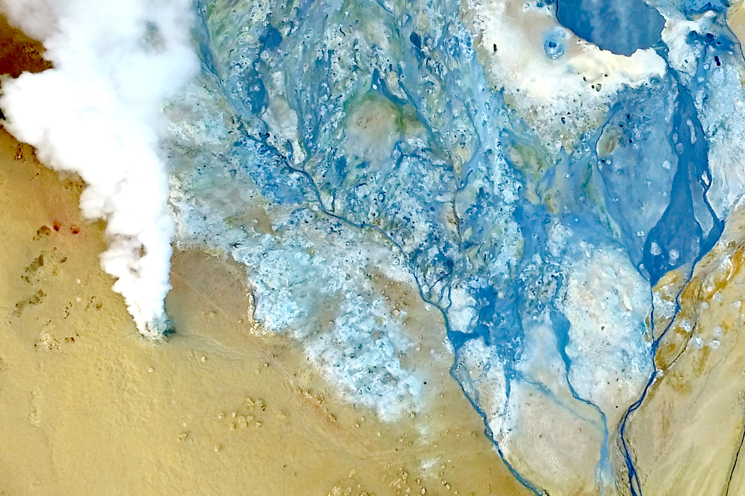 An areal photo of a bubbling mud pit 