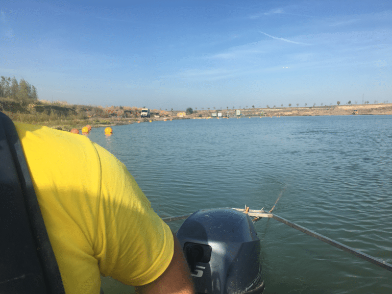 A photograph from the back of a boat looking over a dam