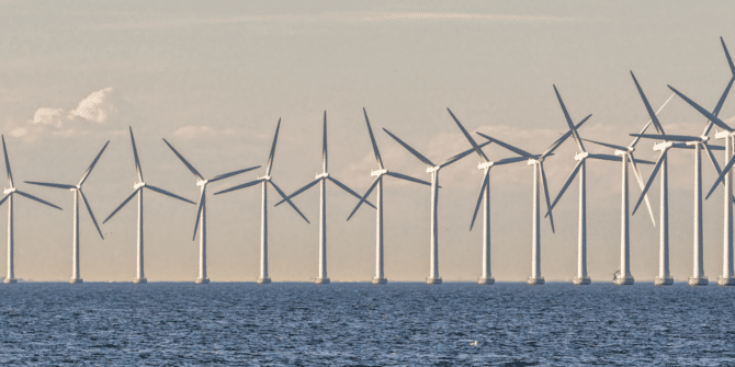 A photograph of wind turbines in the ocean