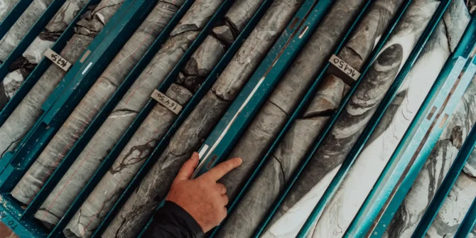 Geological gold core samples with team of mining workers measuring drilled rock top view. Selective focus. shutterstock_2128256828