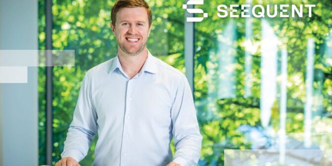 A photograph of a smiling man with the Seequent logo
