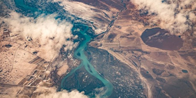 a photo from up high looking down over a river, with clouds obscuring some of the view