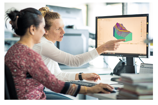 A picture of two women looking at a geological model on a screen