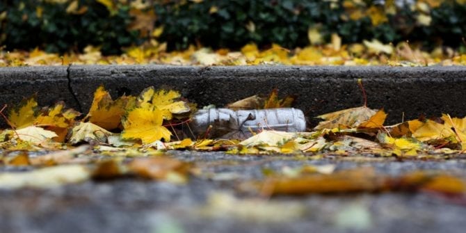 plastic water bottle rubbish in the gutter with leaves