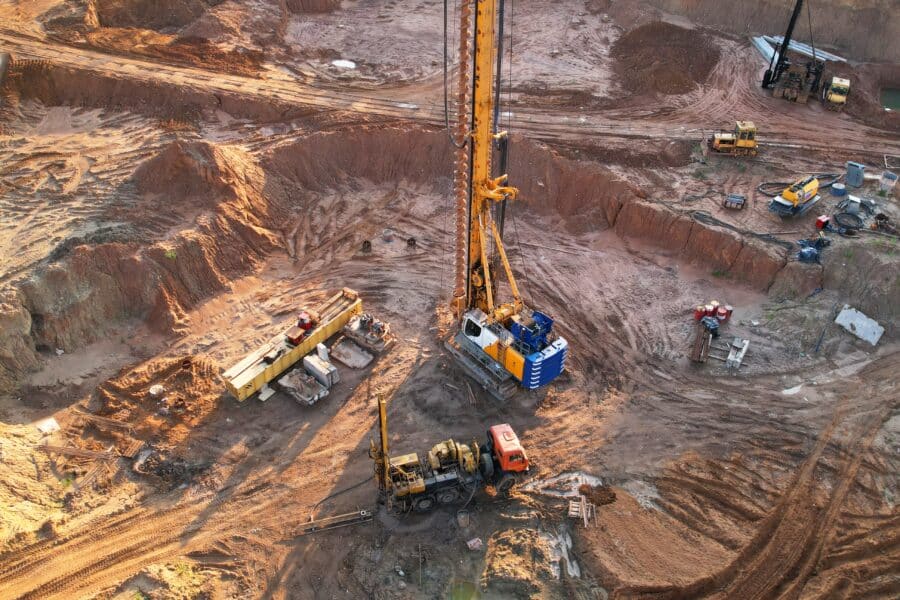 A photograph of an exploration and mining environment that has a core drill and various vehicles and pieces of machinery
