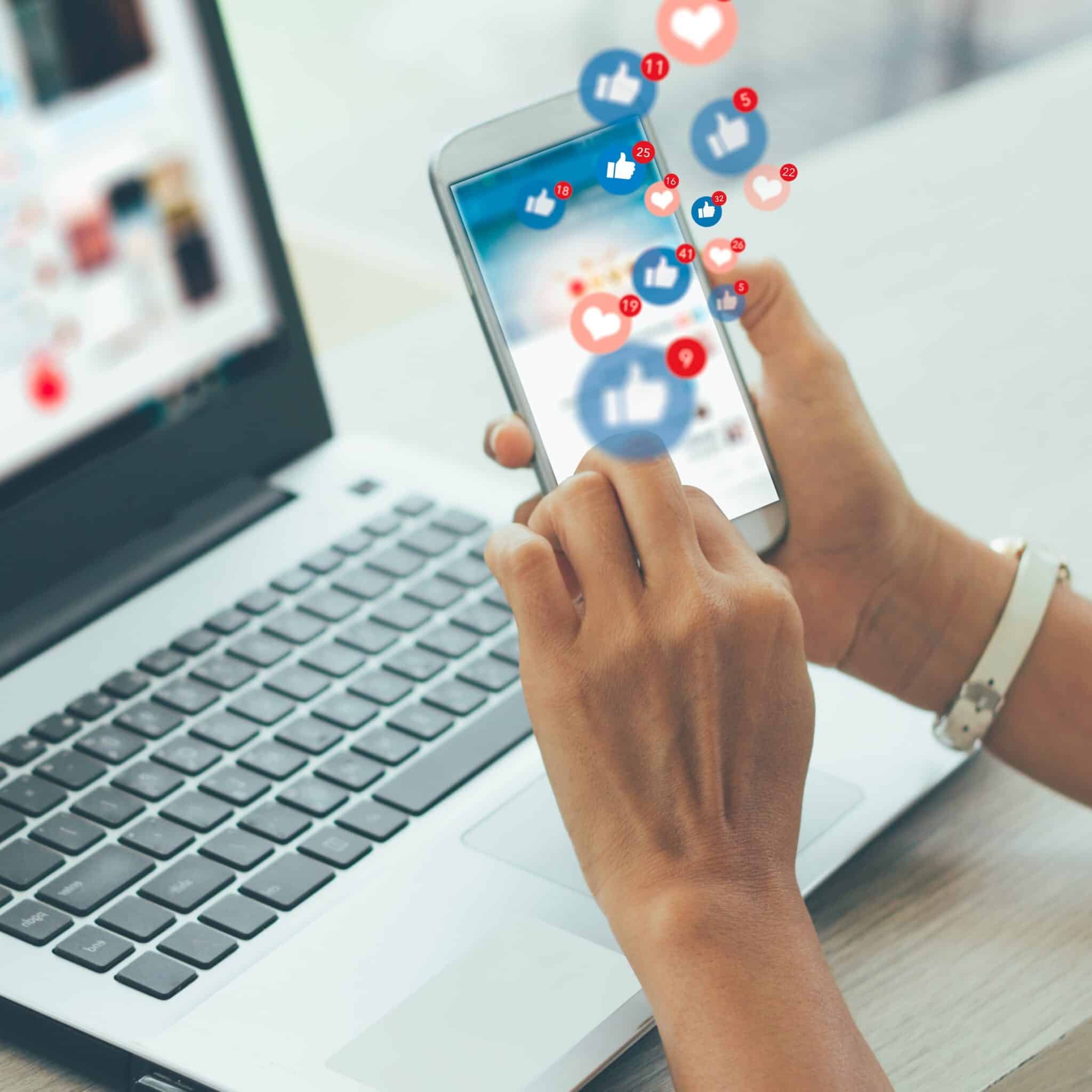 A photograph of a woman holding a phone with social media likes and hearts floating out of the screen