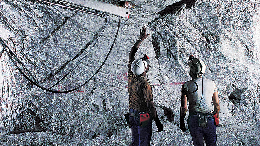Geologists looking at rock in underground cavern.